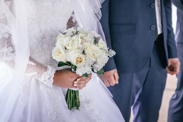 Bouquet de mariée entre les mains de la mariée