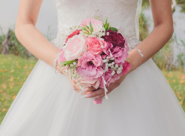 Bouquet de mariée entre les mains de la mariée