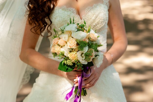 Bouquet de mariée entre les mains de la mariée