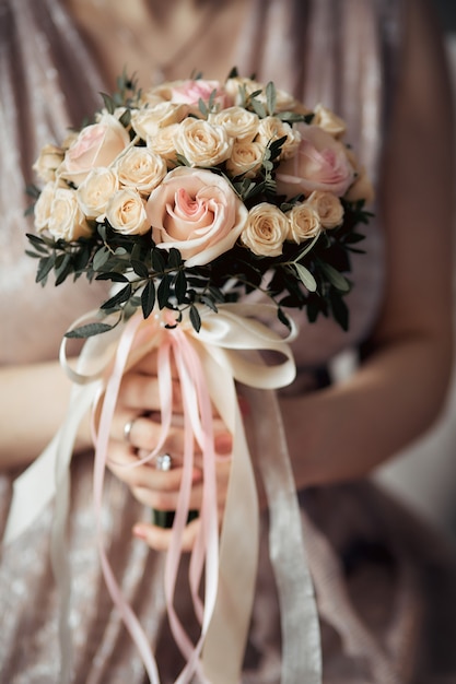 Bouquet de mariée entre les mains de la mariée