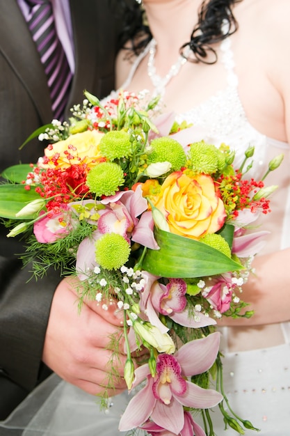 Bouquet de mariée entre les mains des mariés