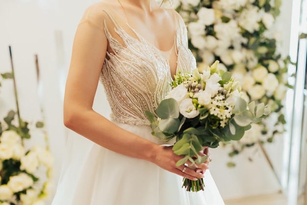 bouquet de mariée avec des fleurs blanches dans les mains de la mariée