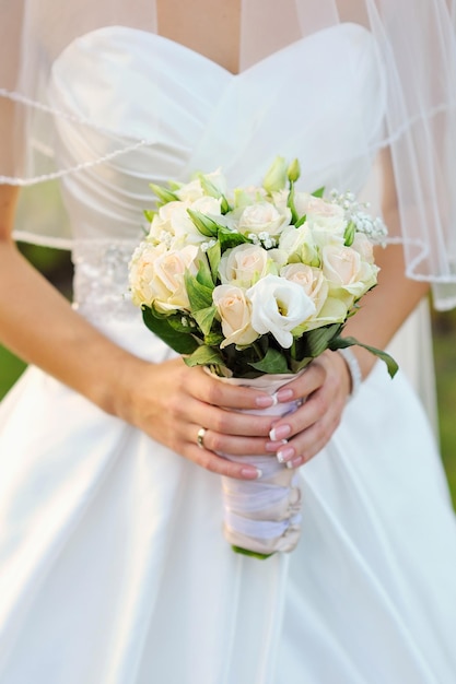 Bouquet de mariée de fleurs roses et blanches dans les mains de la mariée