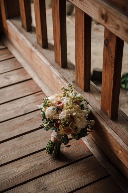 Bouquet de mariée sur le fond en bois. Bouquet de roses et pivoines. Mariage.