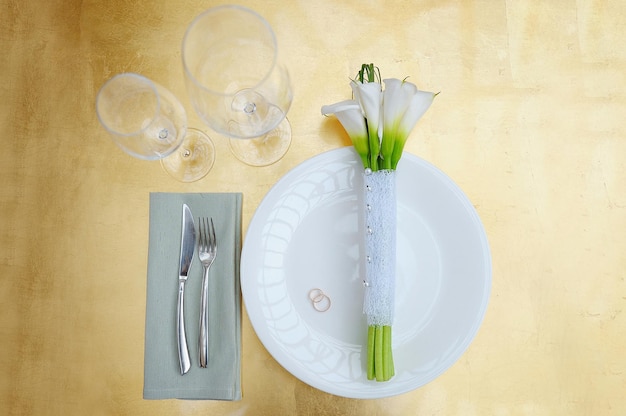 Bouquet de mariée de lys calla sur une table sur une assiette