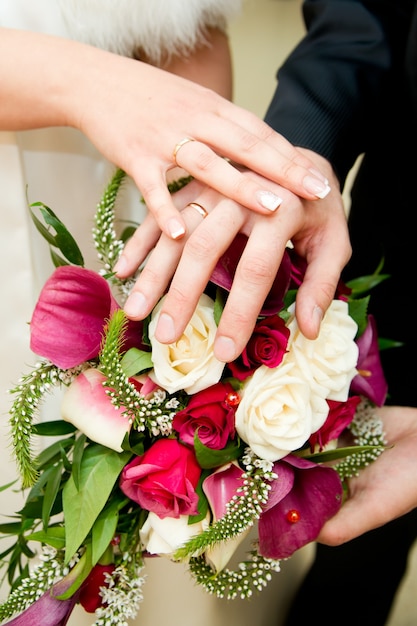 Bouquet de mariée et mains avec anneaux
