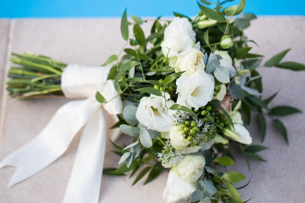 Bouquet de mariée de mariage sur un gros plan de fond bleu.