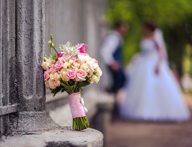 Bouquet de mariée avec des mariés flous