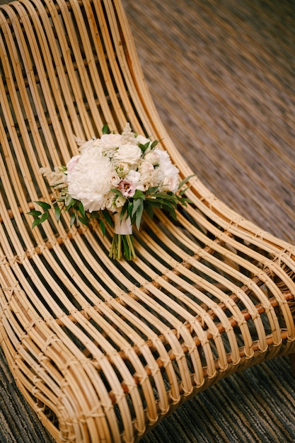 Bouquet de mariée de pivoines blanches roses roses eustoma astilbe et branches d'eucalyptus sur une paille