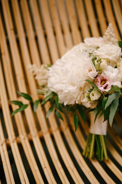 Bouquet de mariée de pivoines blanches roses roses eustoma astilbe et branches d'eucalyptus sur une paille