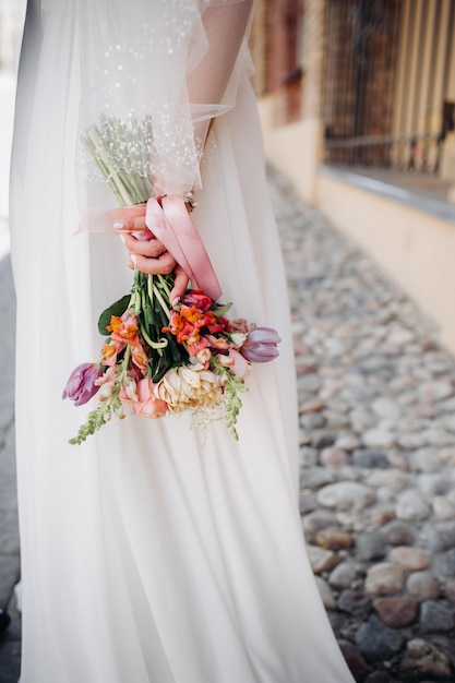 Bouquet de mariée avec des pivoines dans les mains de la mariée sous le voile.Matin de la mariée.