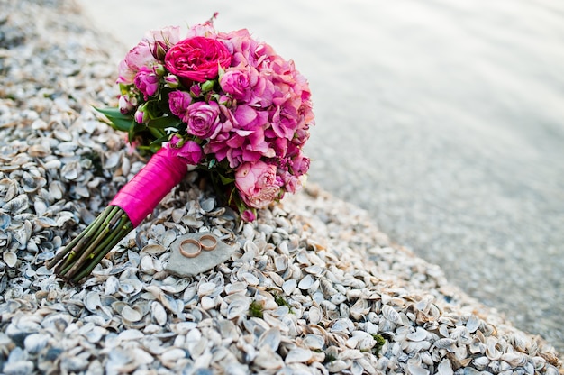 Bouquet de mariée rose élégant avec des anneaux aux coquilles