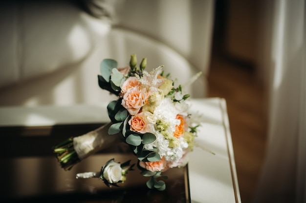 Bouquet de mariée avec roses et boutonnière. Le décor au mariage