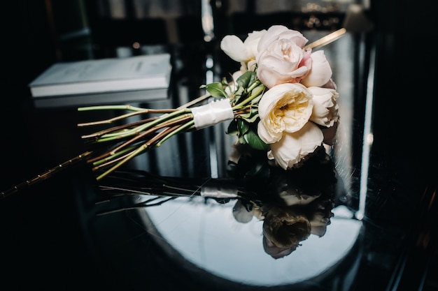 Photo bouquet de mariée avec roses et boutonnière.