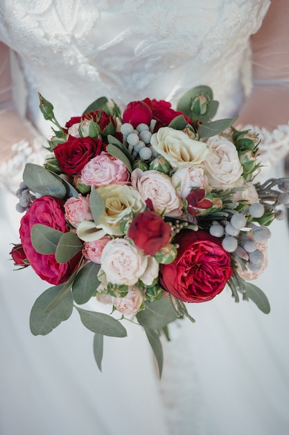 Bouquet de mariée avec des roses dans les mains de la mariée