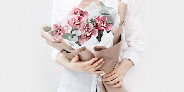 Bouquet à la mode avec des orchidées rouges dans les mains de la femme