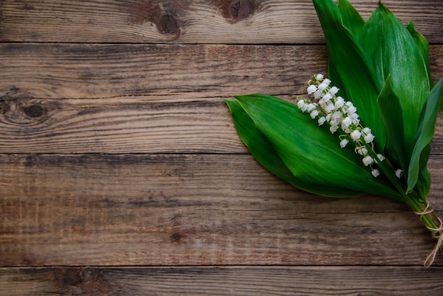 Bouquet de muguet sur une surface en bois avec espace copie