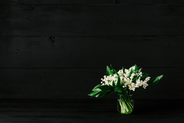 Bouquet de muguets sur un fond en bois noir