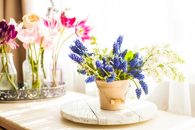 Bouquet de muscaris dans un seau en céramique. Printemps nature morte près de la lumière de la fenêtre