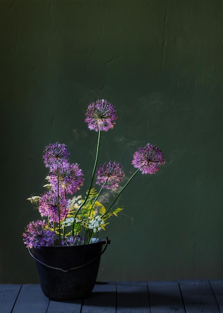 Bouquet d'oignons décoratifs fleuris dans un vase en verre