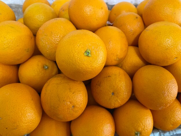 Un bouquet d'oranges est empilé et l'un a une marque verte sur la pointe.