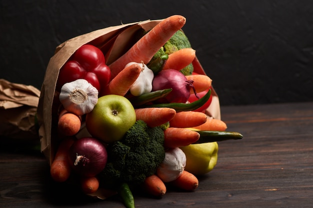 Le bouquet original de légumes comestibles inhabituel sur un bois sombre