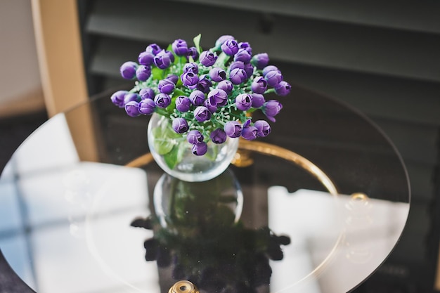 Un bouquet de petites fleurs bleues sur une table en verre 1976