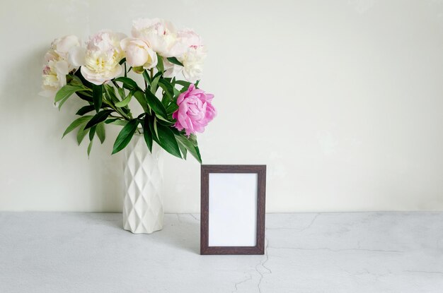 Bouquet de pivoines blanches dans un vase sur fond gris