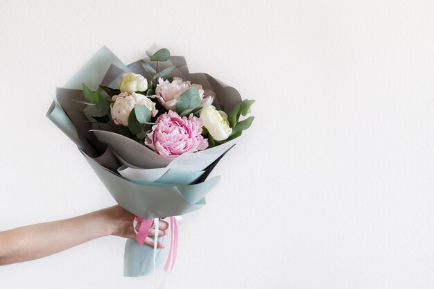 Bouquet de pivoines avec des branches d'eucalyptus à la main