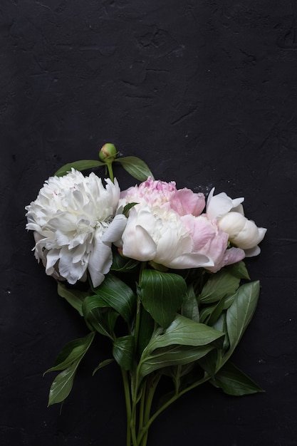 Bouquet de pivoines sur table noire