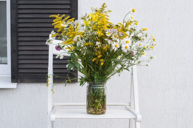 Bouquet en pot sur fond de mur de maison blanche