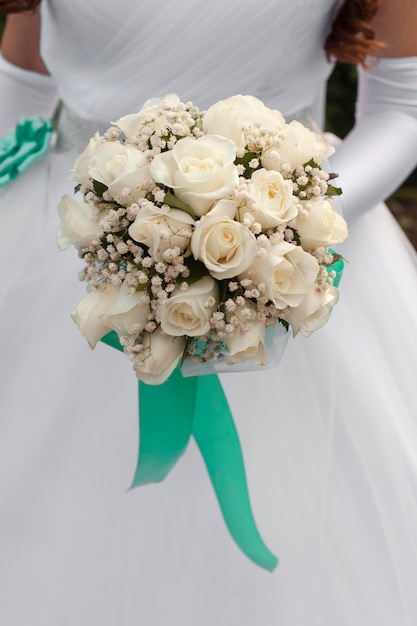 Bouquet de roses blanches dans les mains de la mariée