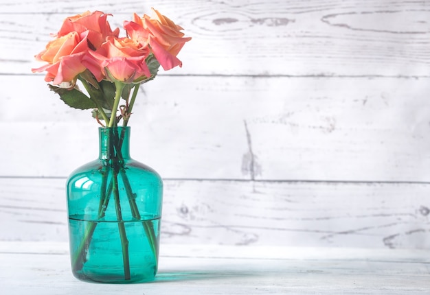 Bouquet de roses dans le vase sur le fond en bois