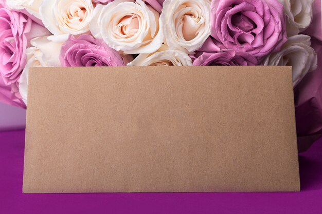 Bouquet de roses fraîches blanches et violettes étonnantes et enveloppe artisanale