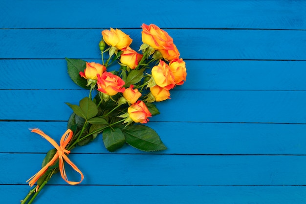 bouquet de roses orange sur bois bleu