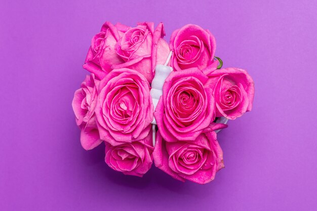 Bouquet de roses roses fraîches dans un seau. Le concept festif pour les mariages, les anniversaires, le 8 mars, la fête des mères ou la Saint-Valentin. Carte de voeux, fond lilas