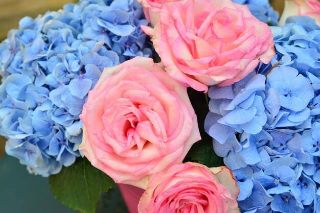 Bouquet de roses roses et d'hortensias bleus dans un vase