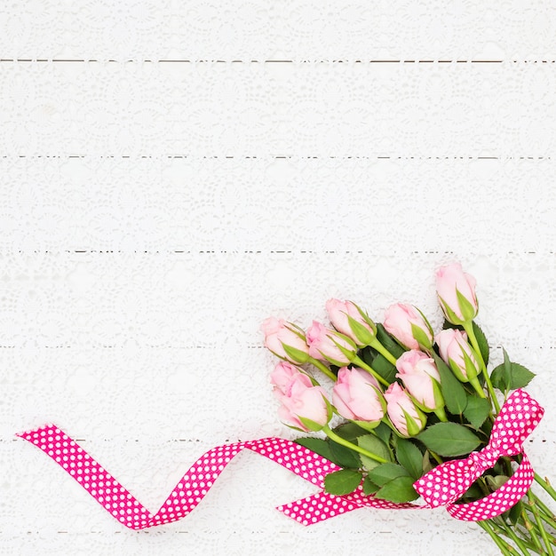 Bouquet de roses roses sur une nappe blanche