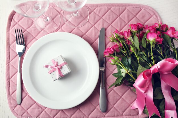 Bouquet de roses roses sur une table servie en gros plan