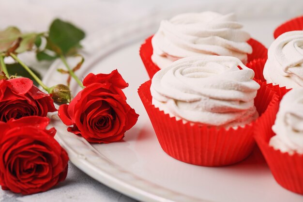 Bouquet de roses rouges et blanches fraîches, avec dessert