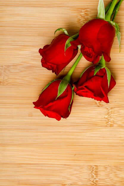 Bouquet de roses rouges et boîte-cadeau sur planche de bois. Concept de la Saint-Valentin