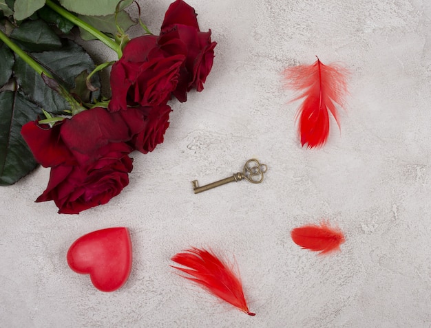 Bouquet de roses rouges, un coeur, une clé et des plumes rouges