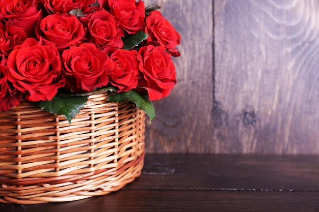 Bouquet de roses rouges dans le panier sur fond de bois