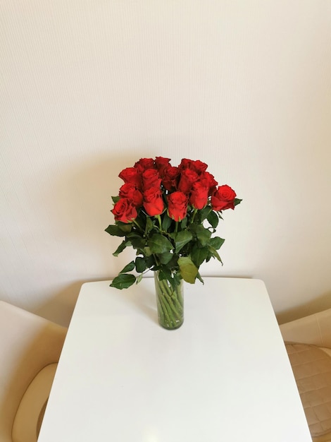 Bouquet de roses rouges dans un vase en verre sur la table