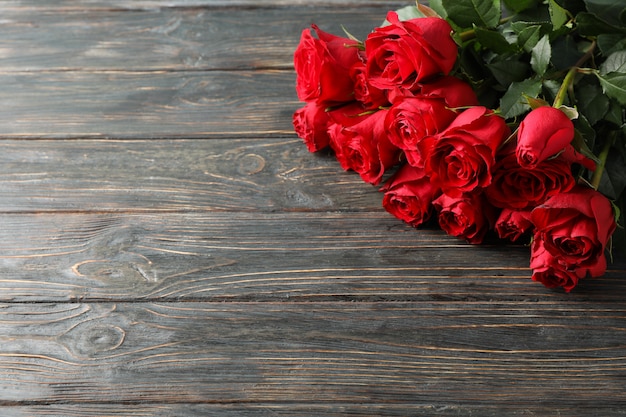 Bouquet de roses rouges sur fond en bois, espace pour le texte