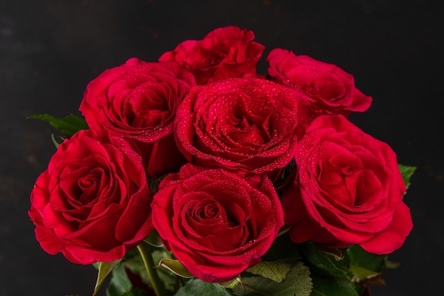 Bouquet de roses rouges sur fond sombre.