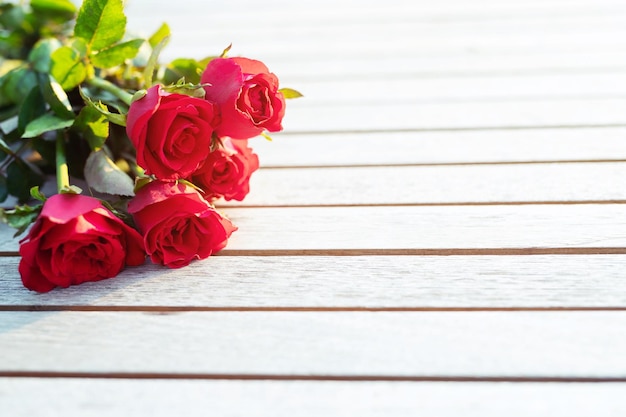 Un bouquet de roses rouges fraîches fleur nature belles fleurs sur la table vintage en bois Matin lumière du soleil espace de copie vide écrire des messages dans le mariage de la Saint-Valentin ou le concept d'amour romantique