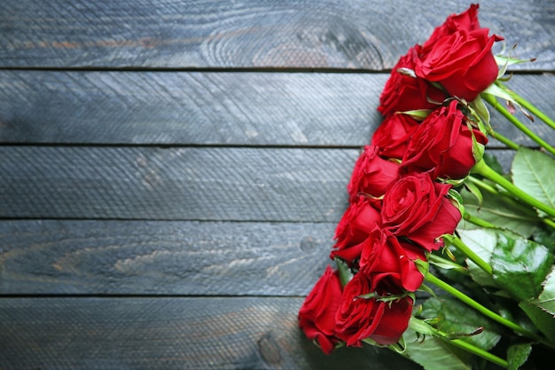 Bouquet de roses rouges fraîches sur fond de bois