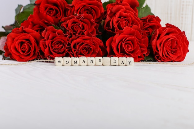 Un bouquet de roses rouges et l'inscription sur les perles