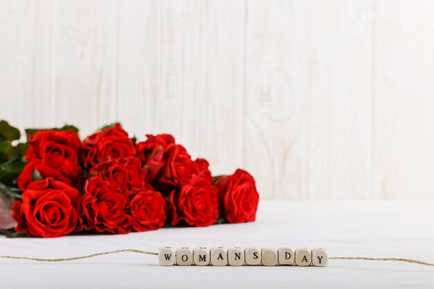 Un bouquet de roses rouges et l'inscription sur les perles